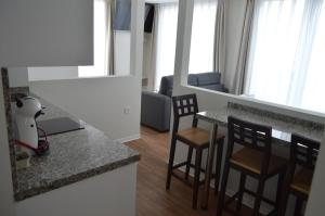 a kitchen and living room with a table and chairs at Apartamentos el Beyu in Cangas de Onís