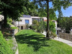 an exterior view of a house with a green yard at Casa do Passal Country House in Paço de Sousa