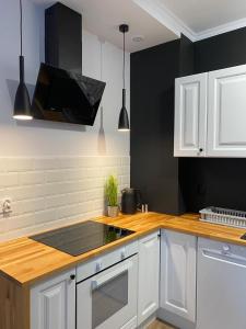 uma cozinha com armários brancos e um forno com placa de fogão em Apartament Platinum Park em Stargard