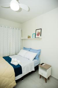 a bedroom with a bed and a table with towels at Pousada Vila da Praia in Maricá
