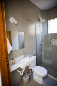 a bathroom with a toilet and a sink and a shower at Pousada Vila da Praia in Maricá