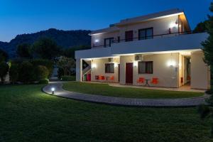 a house with a lawn in front of it at night at Angela Studios Pefkos in Pefki