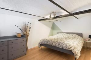 um quarto com uma cama e uma cómoda em Beautiful loft in a former factory in Tourcoing - Welkeys em Tourcoing