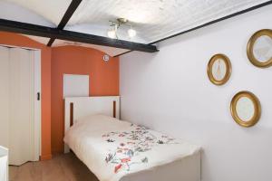 - une chambre avec un lit et deux miroirs sur le mur dans l'établissement Beautiful loft in a former factory in Tourcoing - Welkeys, à Tourcoing