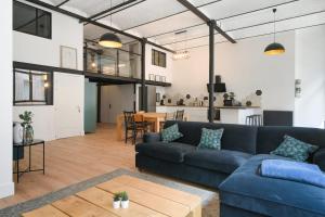 a living room with a blue couch and a table at Beautiful loft in a former factory in Tourcoing - Welkeys in Tourcoing