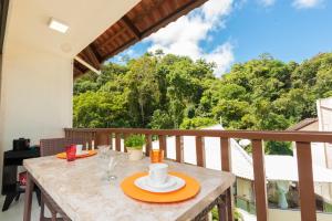 a table on a balcony with a view of trees at Dei Fiori Guaramiranga in Guaramiranga