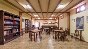 una habitación con mesas y sillas en una biblioteca en Hotel Rural Restaurante Mahoh en Villaverde