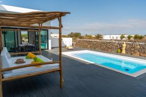 a bedroom with a bed and a swimming pool at Villa Santiago in Lajares