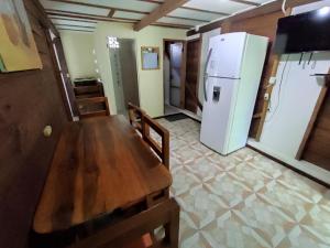 a kitchen with a wooden table and a refrigerator at Wasimita in Crucita