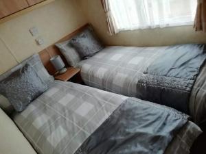 a bedroom with two beds and a window at Port Haverigg Millom in Millom