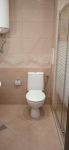 La salle de bains est pourvue d'une douche et de toilettes blanches. dans l'établissement Residence Park Sarafovo Apart, à Bourgas