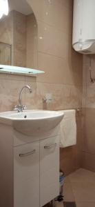 La salle de bains est pourvue d'un lavabo blanc et d'un miroir. dans l'établissement Residence Park Sarafovo Apart, à Bourgas