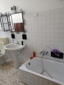 a bathroom with a sink and a tub and a toilet at Villa Quinto in Pisticci