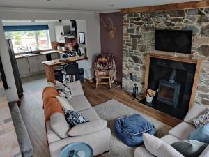 a living room with a couch and a fireplace at Biking in the Borders in Innerleithen