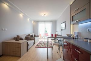 a kitchen and living room with a couch and a table at Słoneczny Apartament in Giżycko