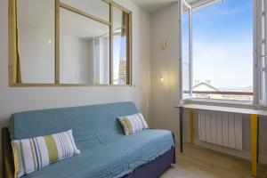 a bedroom with a blue bed and a large window at Charming 1br flat with sea view at the heart of Biarritz - Welkeys in Biarritz