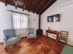 a living room with two chairs and a desk at Monte do Brejinho de Água in Carvalhal