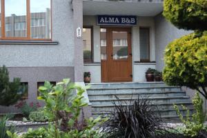 uma porta da frente de um edifício com um sinal de saco de aania em Alma B&B em Kalvarija