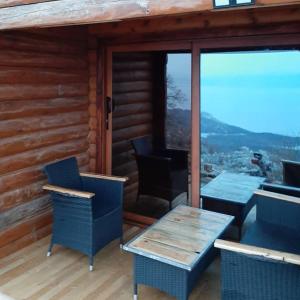 patio ze stołami i krzesłami na drewnianym domku w obiekcie Livari Rooms Exclusive Chalet w Barze