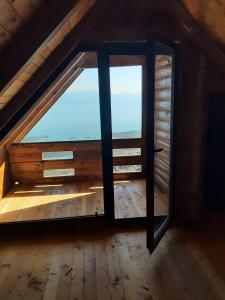 an attic window with a view of the ocean at Livari Rooms Exclusive Chalet in Bar