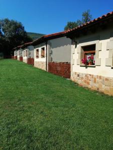 una fila di case con un cortile verde di EL ATERPE a Aldehuela del Rincón