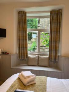 a window with two towels on a bed in front of it at Black Bull Inn in Haworth