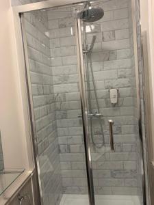 um chuveiro com uma porta de vidro na casa de banho em Black Bull Inn em Haworth
