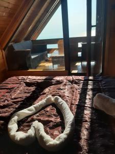 Bett in einem Zimmer mit einem großen Fenster in der Unterkunft Livari Rooms Exclusive Chalet in Bar