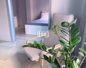 uma cadeira e uma planta num quarto com um espelho em inn Kalamata Urban Suites DT em Kalamata