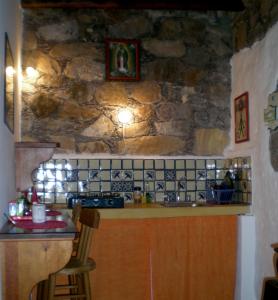 a kitchen with a counter and a stone wall at Casa Curtos in Real de Catorce