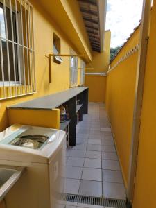 a laundry room with a washing machine in a yellow wall at Tudo de Bom in Caraguatatuba