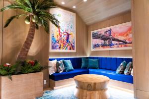 a living room with a blue couch and a palm tree at Margaritaville Resort Times Square in New York