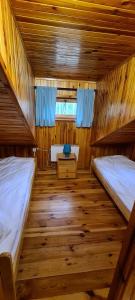 a room with two beds in a wooden cabin at Ośrodek Wypoczynkowy Bledzewo in Bledzewo