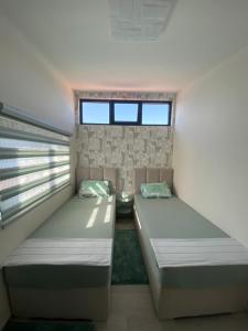 Martin Lux Apartment في كراشيسي: سريرين في غرفة بها نافذتين