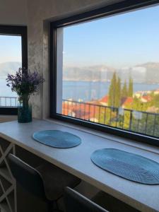 zwei blaue Platten auf einem Tisch mit einem Fenster in der Unterkunft Martin Lux Apartment in Krasići