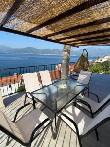 a dining table and chairs on a balcony with the ocean at Martin Lux Apartment in Krasici