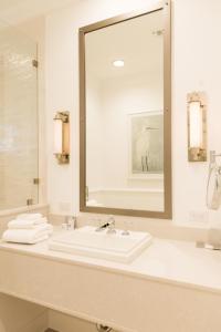 uma casa de banho com um lavatório e um espelho grande em Oyster Bay Boutique Hotel em Pensacola