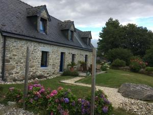 a stone house with flowers in the yard at TY Fine Rose in Riec-sur-Bélon