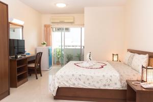 a bedroom with a bed and a desk and a television at K.V.Mansion in Bangkok +29 photos
