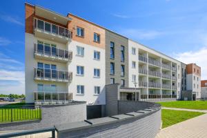 a white building with balconies on the side of it at Apartament Comfort in Suwałki