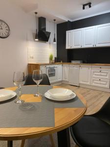 uma cozinha com uma mesa e dois copos de vinho em Apartament Platinum Park em Stargard