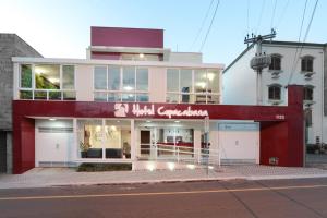 a store front with a red and white building at Hotel Copacabana Piracicaba in Piracicaba