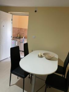 a white table and chairs in a room with a kitchen at Kuca za odmor Harmony in Čurug