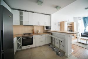 eine Küche mit weißen Schränken und einer Arbeitsplatte in der Unterkunft Apartel Emerald Bay in Mamaia Nord – Năvodari + 10 Fotos