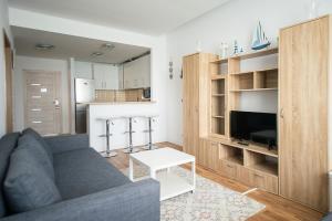 ein Wohnzimmer mit Couch und Fernseher und eine Küche in der Unterkunft Apartel Emerald Bay in Mamaia Nord – Năvodari