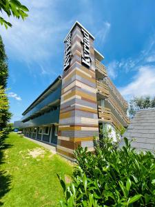 un bâtiment avec un panneau sur son côté dans l'établissement Kyriad Lisieux, à Lisieux