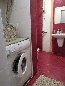uma casa de banho com uma máquina de lavar roupa e um lavatório em 4 Seasons apartments, A2 em Plovdiv