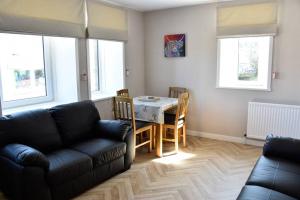 a living room with a couch and a table and chairs at Angus House, 2 Bedroom House, Thurso, NC500 Route in Thurso