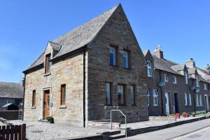 a large brick building with a pointed roof at Angus House, 2 Bedroom House, Thurso, NC500 Route in Thurso