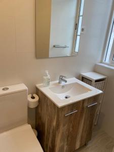 a bathroom with a sink and a toilet and a mirror at RUA NOVA APARTMENT ATICO 3º,a 200m CATEDRAL,PS 4 y NETFLIX in Santiago de Compostela